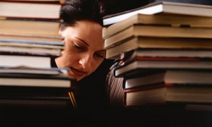 A WOMAN, A STUDENT, STUDYING, SURROUNDED BY BOOKS